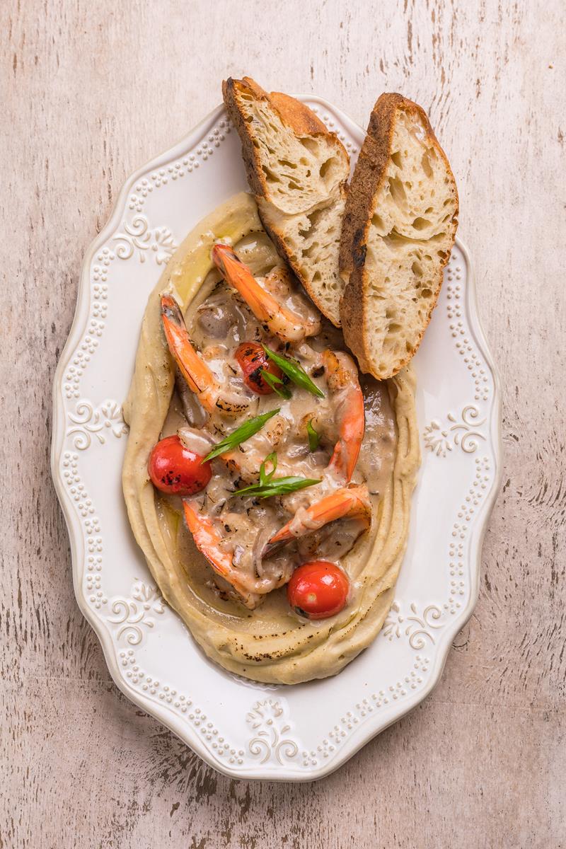 Креветки запечённые с луковым соусом, томатами и хумусом